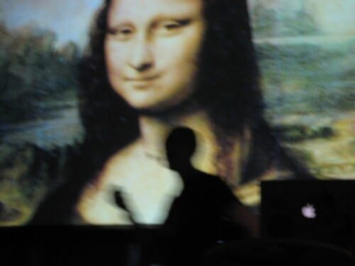 Ben Hammersley dancing around the stage flanked by Mona Lisa and a battered PowerBook